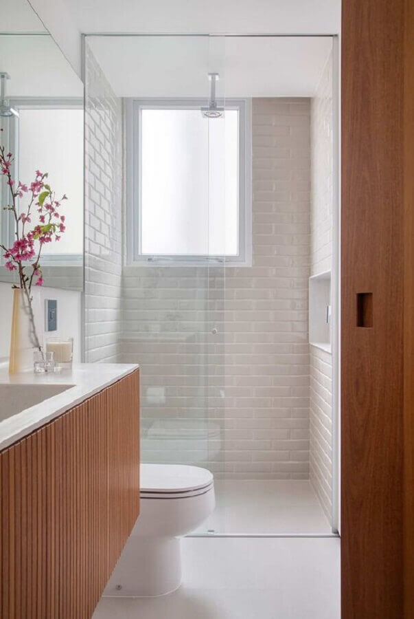 Azulejo branco para banheiro pequeno decorado com gabinete de madeira suspenso Foto AB Design e Interior + Yamagata Arquitetura