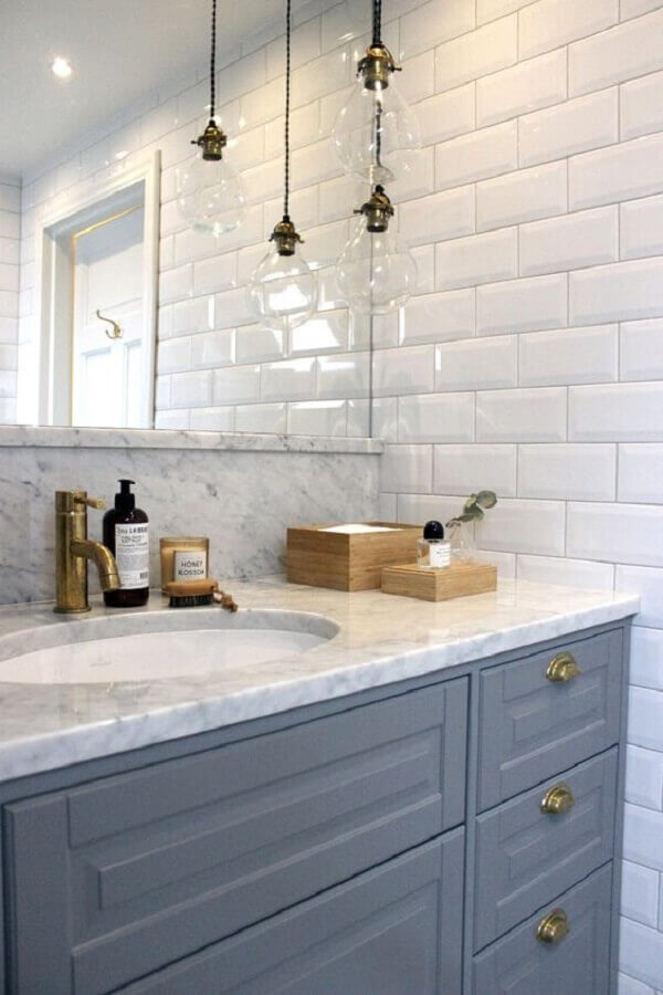 Azulejo tijolinho branco para banheiro decorado com luminária pendente e gabinete cinza clássico Foto Bland damm & dekor