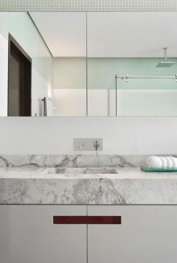 Banheiro com mármore cinza e armário branco 