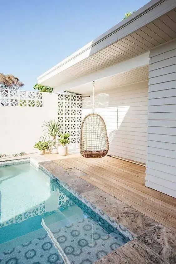 Borda para piscinas modernas no quintal pequeno com cadeiras de balanço 