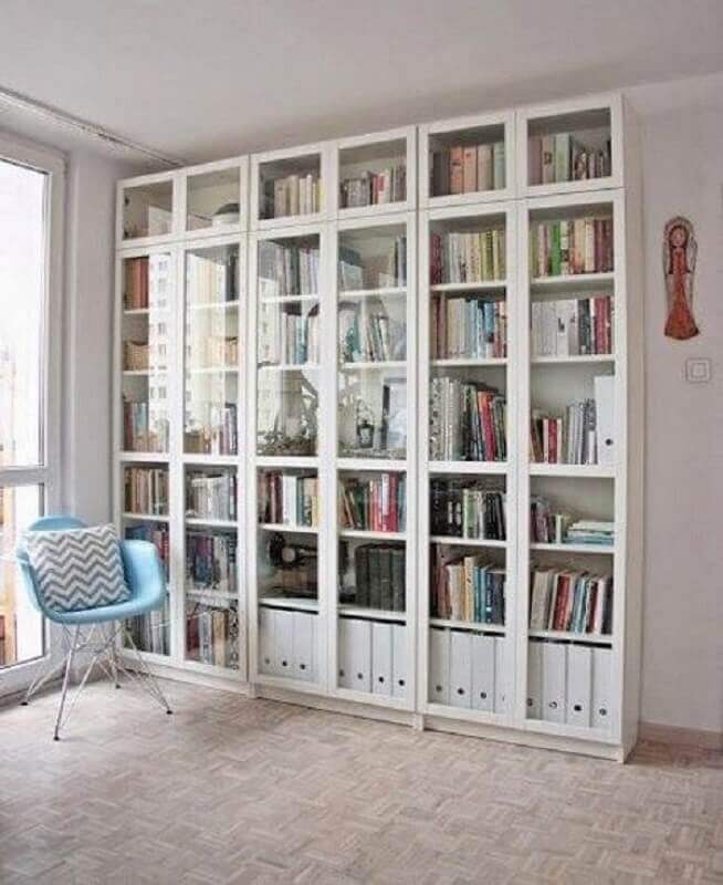 Cantinho de leitura clean decorado com armário para livros fechado com portas de vidro Foto Valente Empreendimentos e Participações