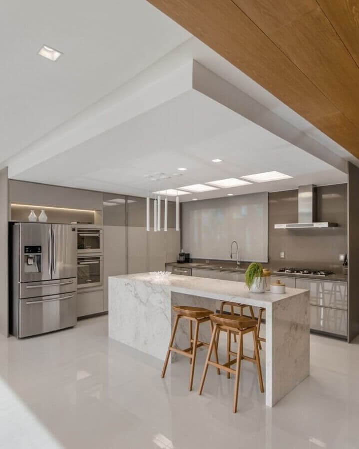 Cores neutras para decoração de cozinha de luxo com ilha de mármore e banquetas de madeira Foto Studio DB Arquitetura