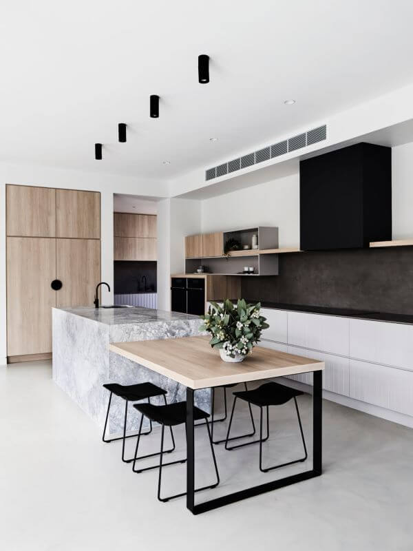 Cozinha com bancada de mármore cinza e mesa de madeira