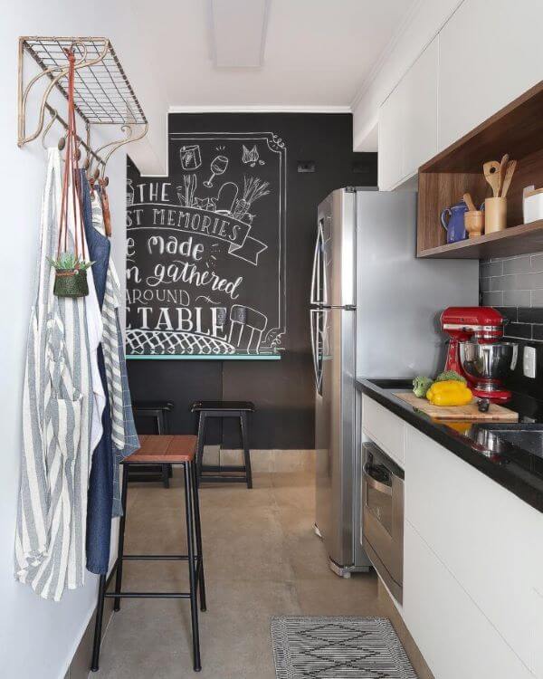 Cozinha com lettering na parede e moveis brancos