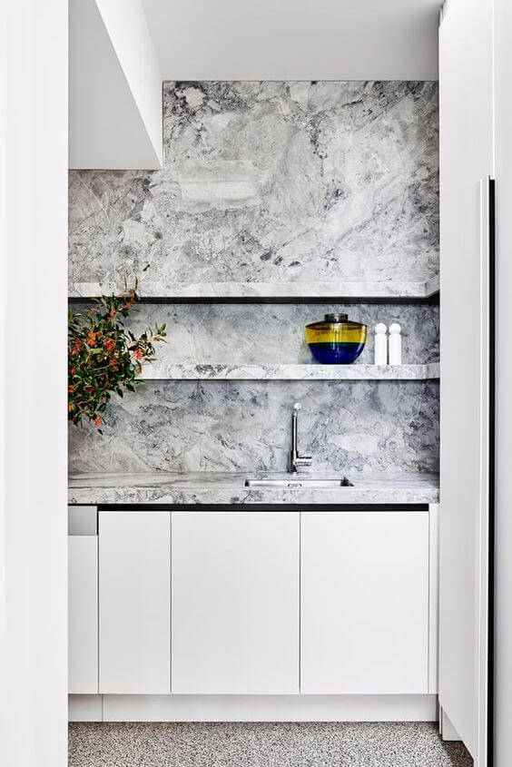 Cozinha com mármore cinza e armário branco