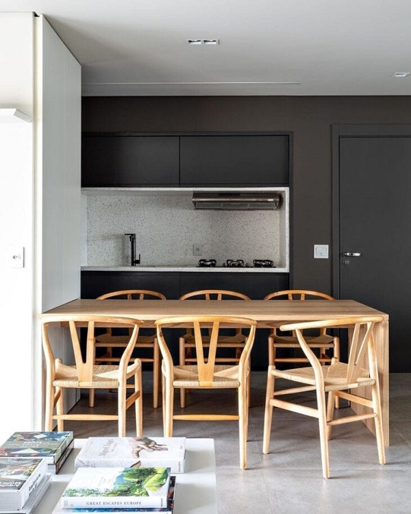 Cozinha com porta preta e mesa de jantar de madeira
