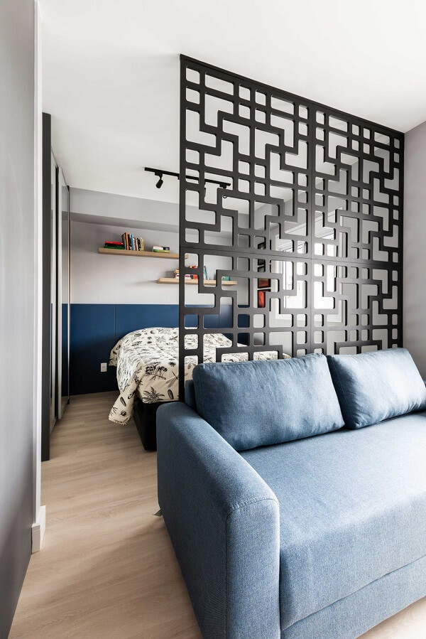 Decoração com divisória de madeira para sala com sofá azul