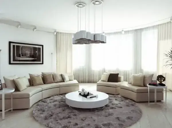 Decoração de sala clean e aconchegante com sofá curvo. Fonte: Home DSGN
