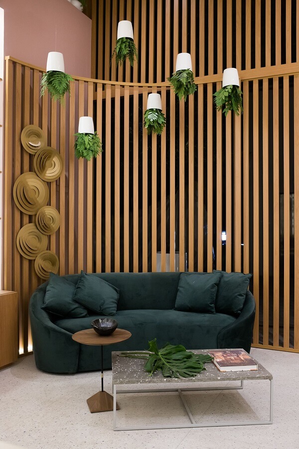 Divisória de madeira curvo para sofá verde e plantas na decoração