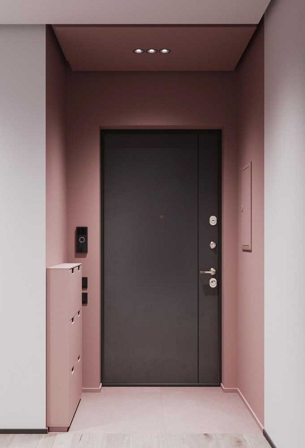 Hall de entrada com porta preta e paredes na cor rosa