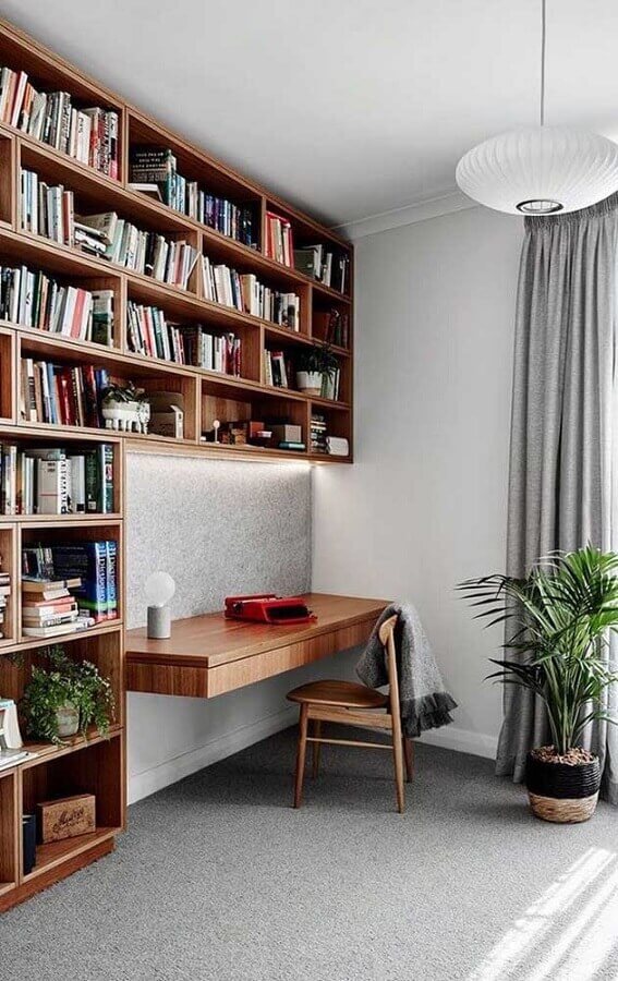 Home office decorado com armário aéreo para livros de madeira Foto Decor Fácil