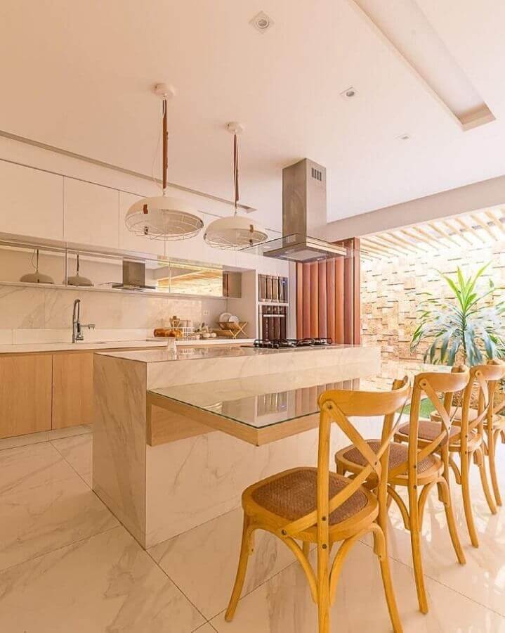 Ilha com cooktop e bancada para decoração de cozinha bege com cadeiras de madeira Foto Studio4
