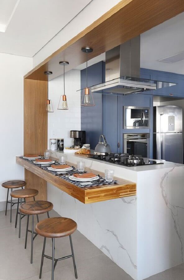 Ilha de mármore com cooktop e bancada de madeira para decoração de cozinha azul Foto Bianchi e Lima Arquitetura
