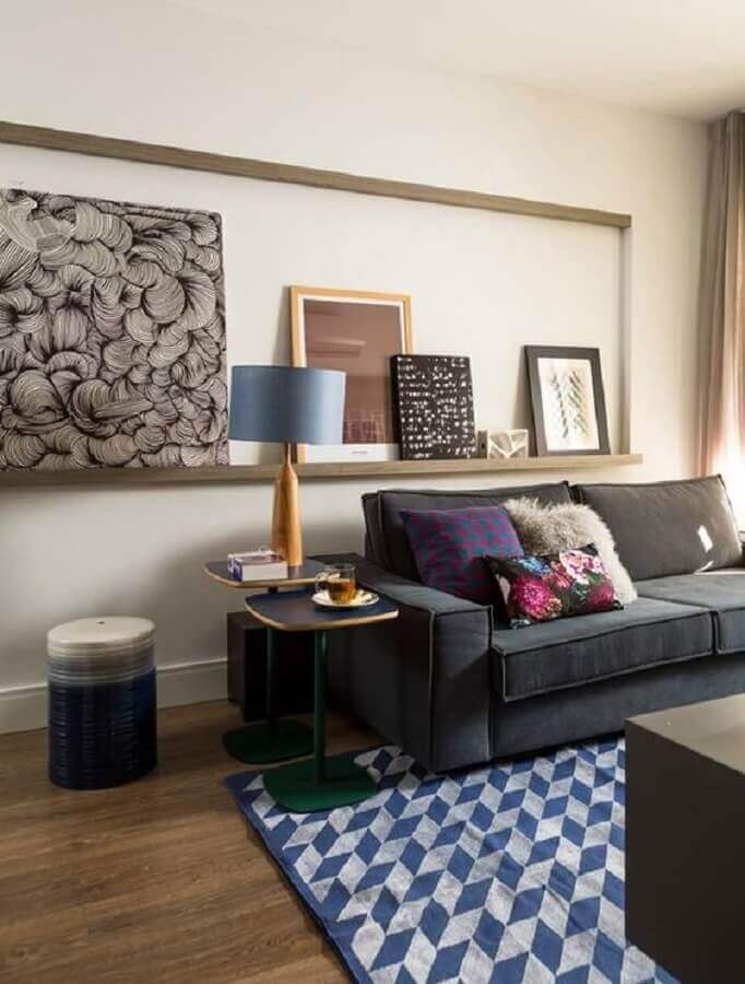  Iluminação de sala de estar decorada com prateleira para quadros e sofa cinza Foto Casa e Jardim