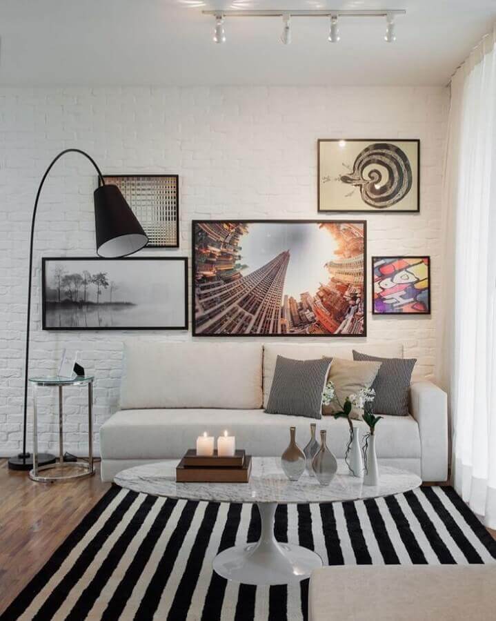 Iluminação para sala de estar branca decorada com tapete listrado e parede tijolinho branco Foto Sesso e Dalanezi Arquitetura
