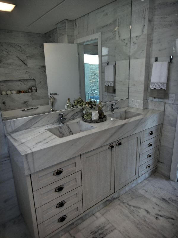 Lavabo revestido de mármore cinza e espelho grande