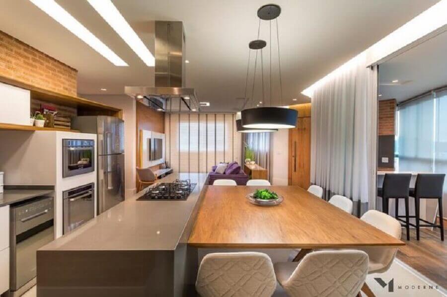Luminária preta para decoração de cozinha com ilha com cooktop e mesa de madeira Foto Moderne Arquitetura