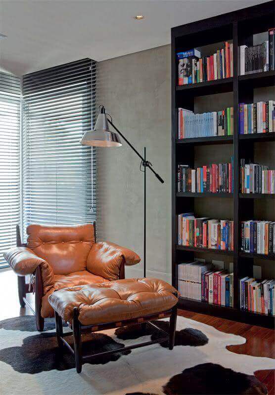 Parede de cimento queimado para escritório moderno decorado com poltrona de couro e armário para livros preto Foto Homify