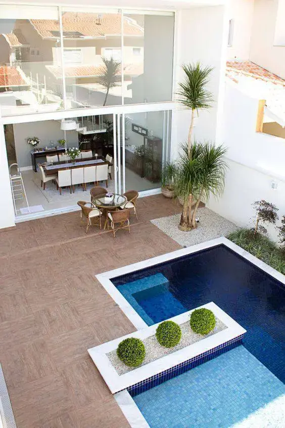 Invista na piscina com borda branca e piso antiderrapante para colocar móveis de madeira resistentes