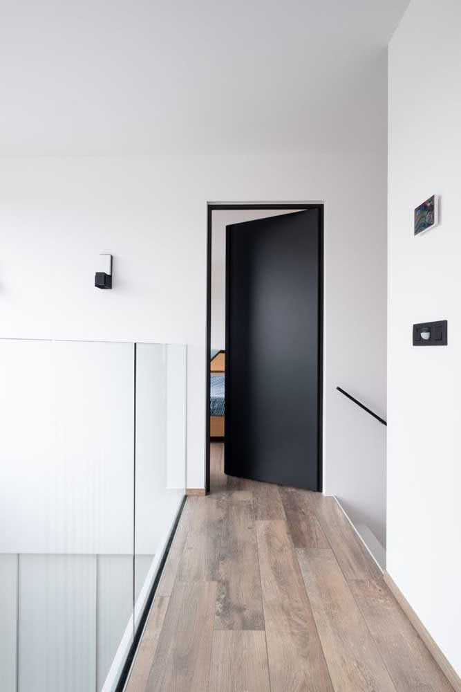 Porta preta de quarto com piso de madeira