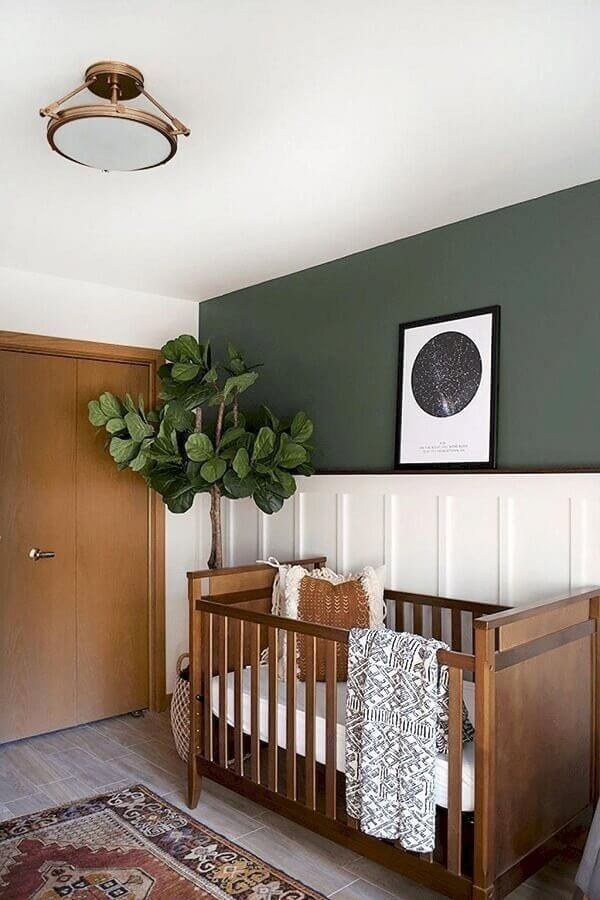 Quarto de bebê unissex simples decorado com meia parede pintada e vaso de planta grande Foto Omah Home