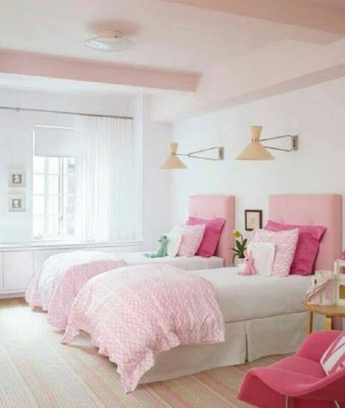Quarto de solteiro compartilhado decorado com luminária de parede e cabeceira rosa clara Foto Better Homes and Gardens