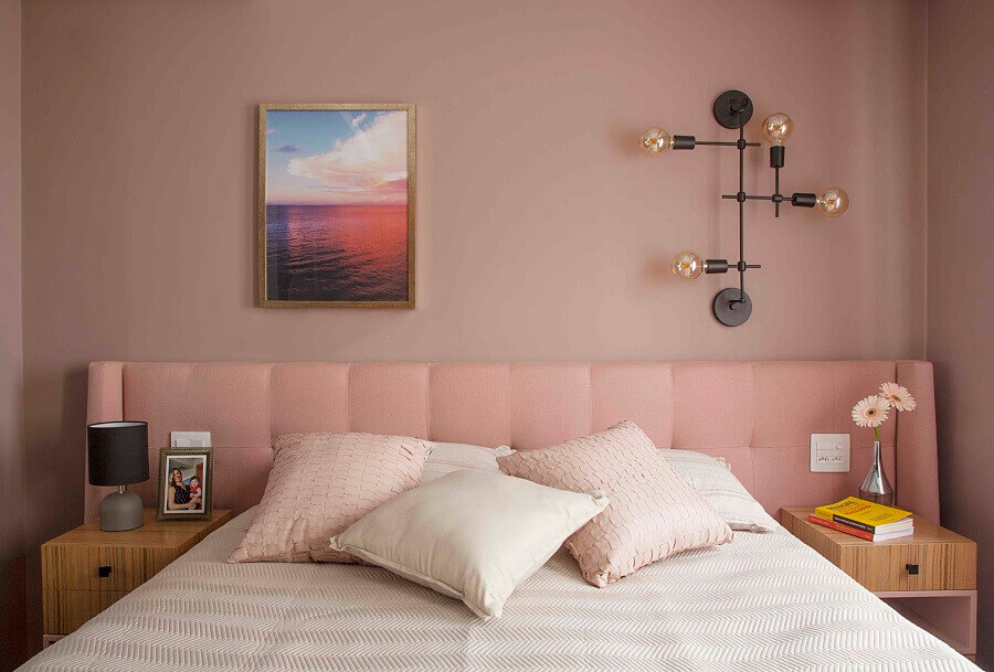 Quarto feminino moderno decorado com luminária de parede e cabeceira estofada rosa Foto Jeito de Casa
