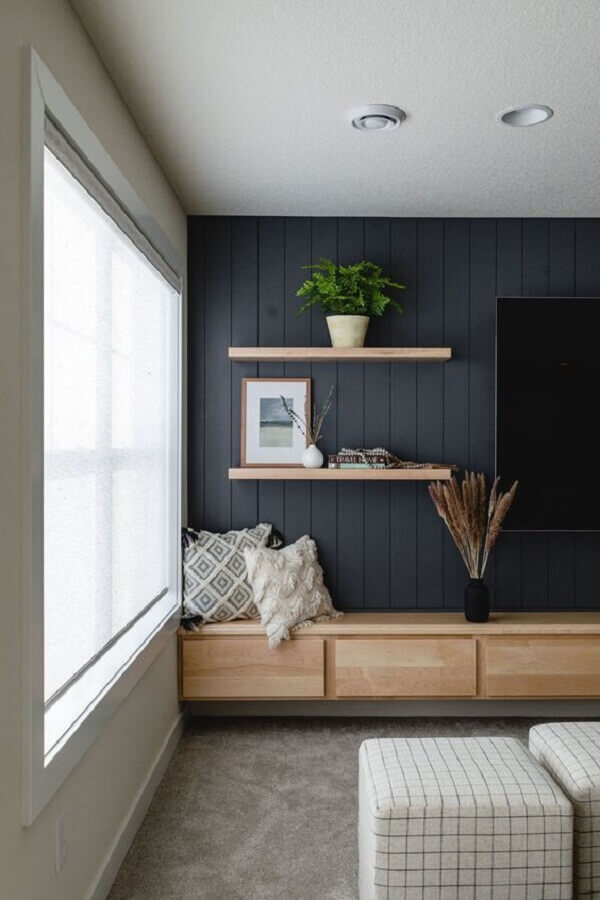 Sala de TV decorada com rack suspenso e parede de lambri de madeira Foto Interiors Addict