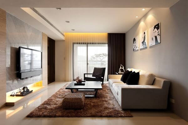 Sala de estar aconchegante com tons de marrom no tapete, puff e cortina