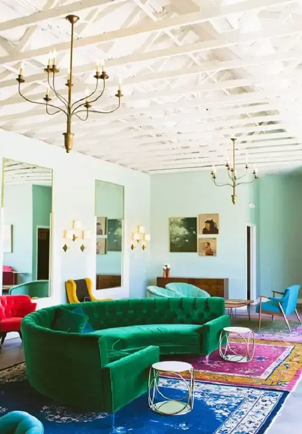 Sala de estar com sofá curvo verde em tecido de veludo. Fonte: Design Love Fest