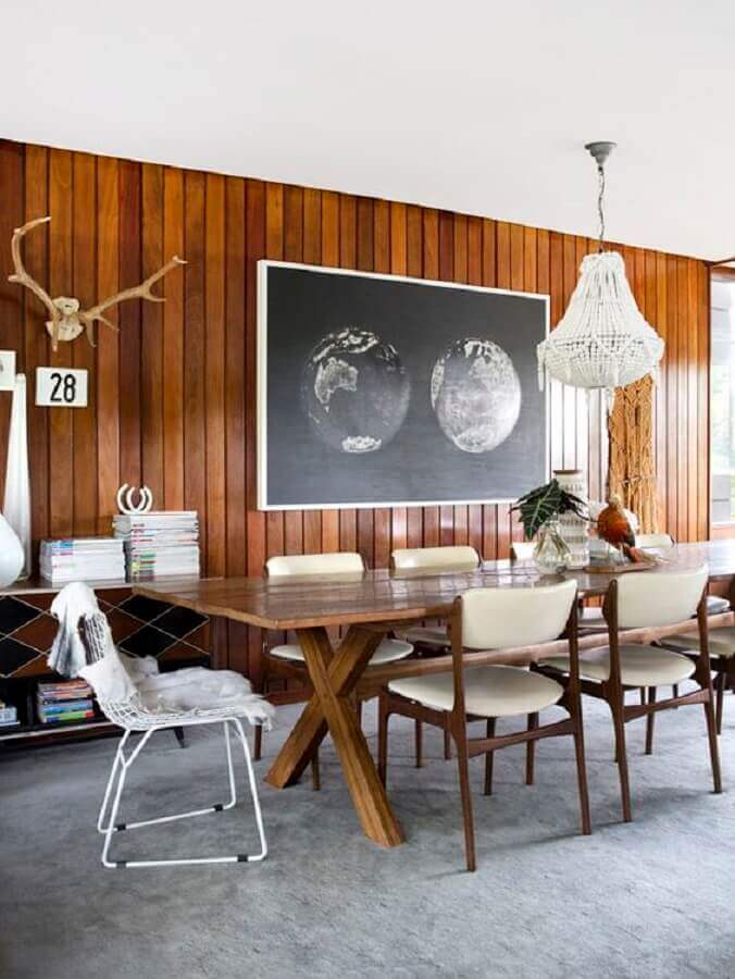 Sala de jantar decorada com lustre de cristal e parede de lambri de madeira Foto The Design Files