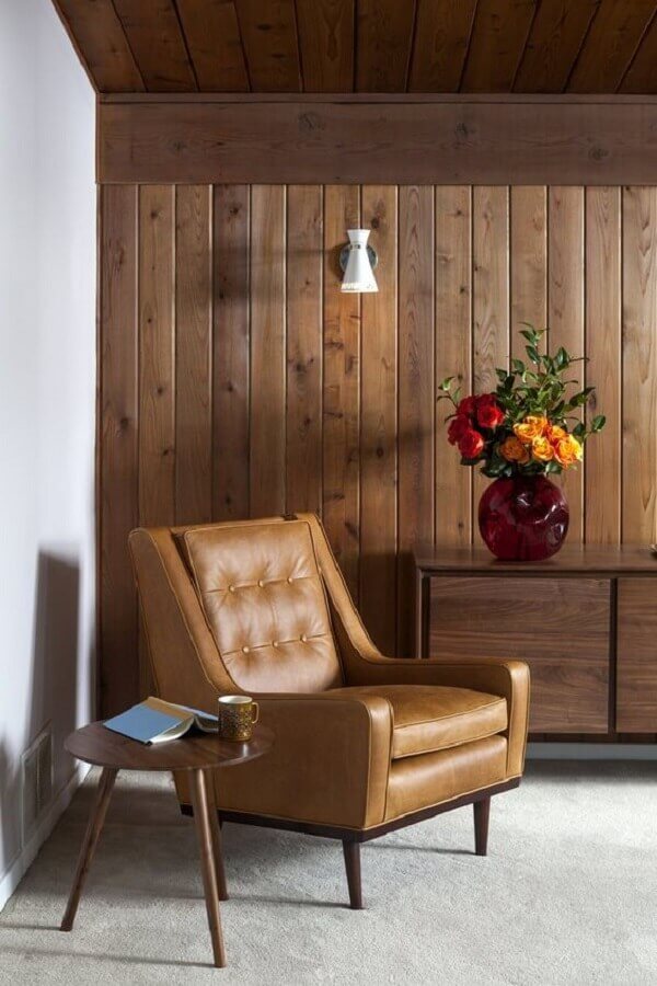 Sala rustica decorada com poltrona de couro e lambri de madeira parede Foto Dwell