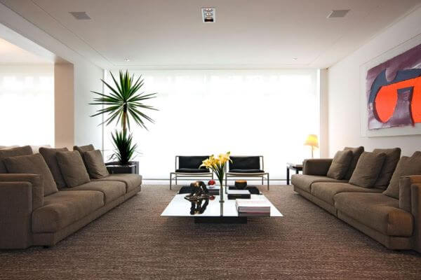 Sala sem tv com conjunto de sofás bege e poltronas pretas