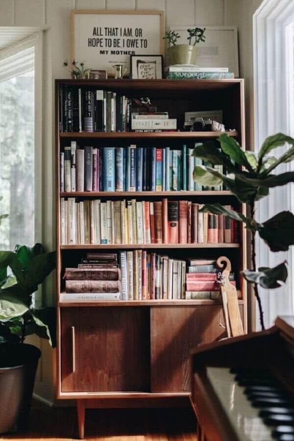 Sala simples decorada com armário para colocar livros de madeira pequeno Foto Casa Vogue