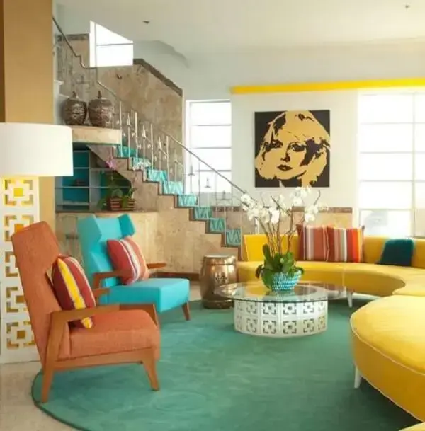 Sofá curvo amarelo e almofadas estampadas coloridas. Fonte: Trend Hunter
