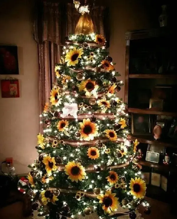 Árvore de natal dourada iluminada com flores de girassol. Fonte: Life as Mama