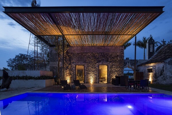 Área externa com pergolado de bambu e piscina