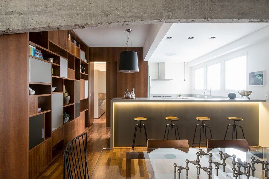 Banco para cozinha americana integrada com sala de jantar decorada com estante de madeira planejada  Foto A.M Studio Arquitetura