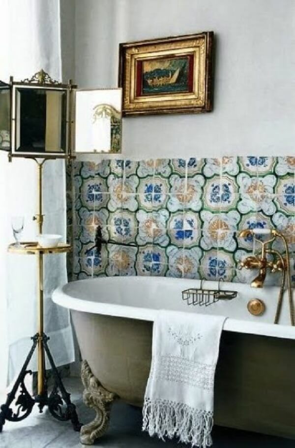 Banheira verde estilo vitoriana combinando com o papel de parede e espelho dourado vintage
