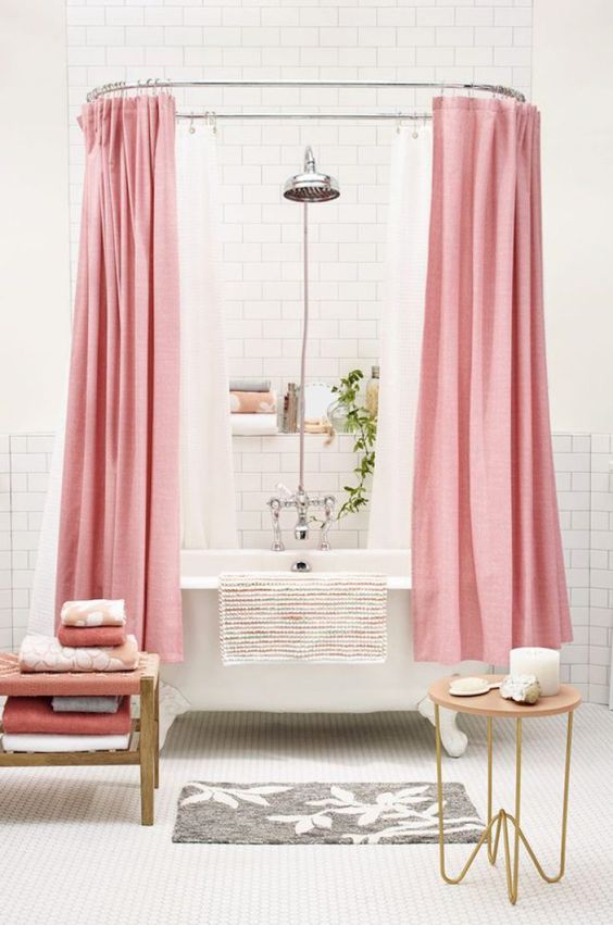 Banheiro branco com banheira vitoriana e cortina rosa 