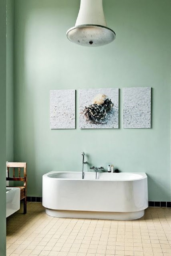 Banheiro com parede verde pastel e banheira branca