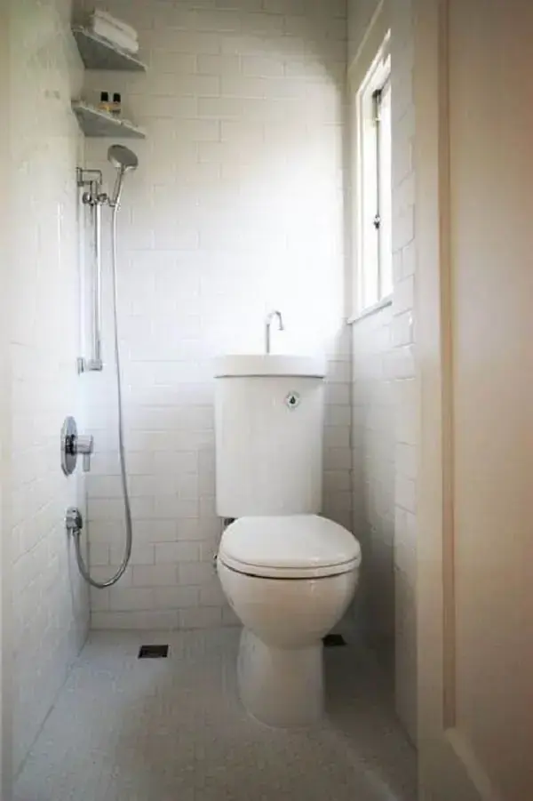 Banheiro embaixo da escada com pia de canto para otimizar espaço. Fonte: Total Construção
