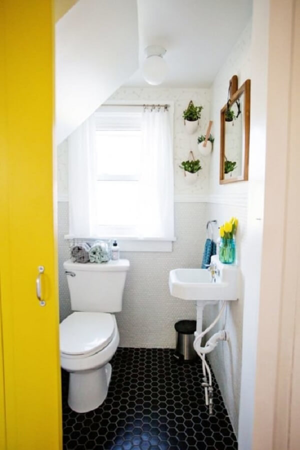 Banheiro pequeno embaixo da escada com porta amarela. Fonte: Decorei