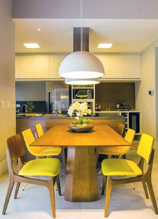 Cadeiras de madeira amarelas para decoração de sala de jantar colorida integrada com a cozinha Foto Archtrends