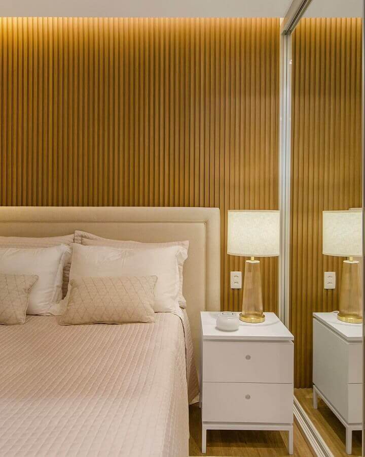 Cores claras para quarto decorado com ripado de madeira na parede e cabeceira estofada Foto Redecker + Sperb Arquitetura