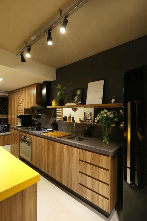 Cozinha de madeira com armário planejado e bancada de granito marrom com cuba de cozinha inox