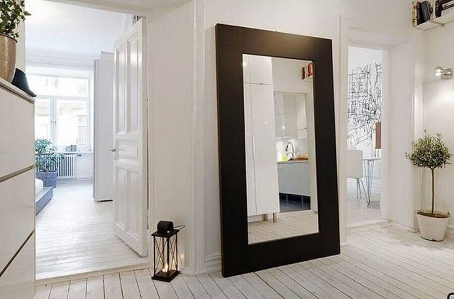 Decoração clean para casa branca com espelho de corpo inteiro com moldura de madeira escura Foto LivingHome