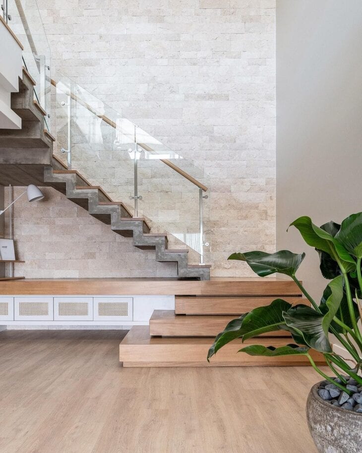 Decoração com escadas modernas de madeira e plantas nos cantos