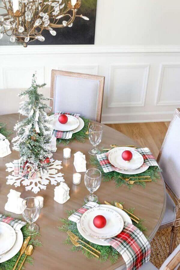 Decoração de mesa de ceia natalina com mini pinheiro e bolas vermelhas Foto Sand and Sisal