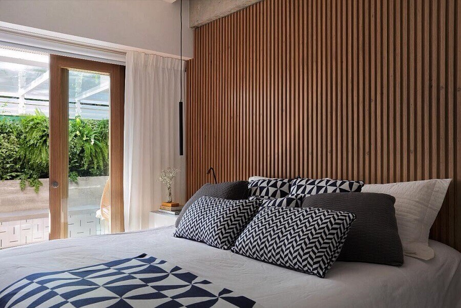Decoração de quarto de casal com almofadas para cama e parede ripada Foto PKB Arquitetura